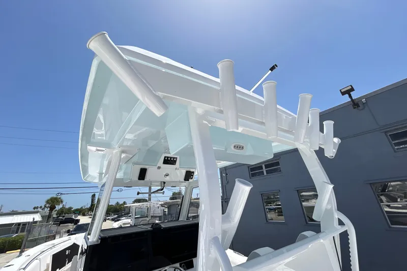 Slide: The Image of 2027 Sea Fox 328 Commander boat with rod holders and electronics under a clear blue sky. - 20