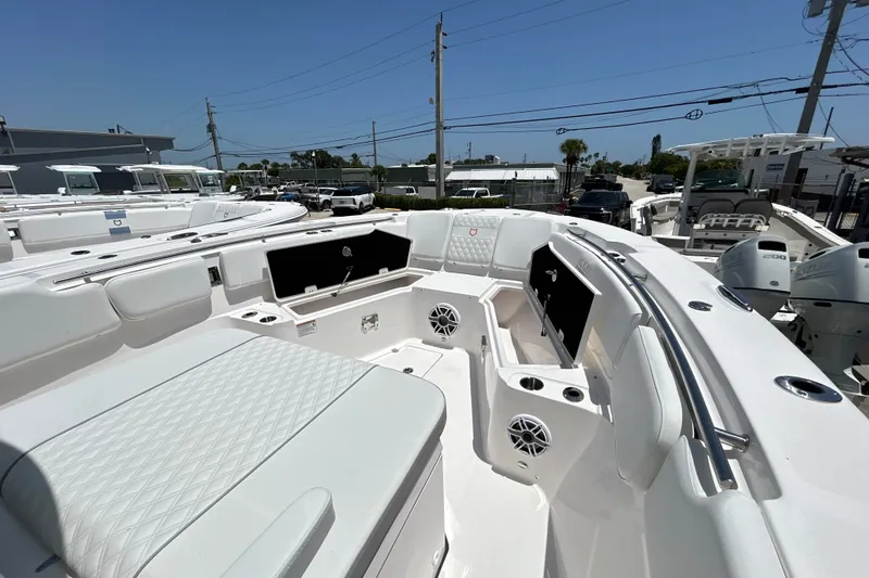 Slide: The Image of 2027 Sea Fox 328 Commander boat interior with seating and speakers, docked under clear skies. - 22