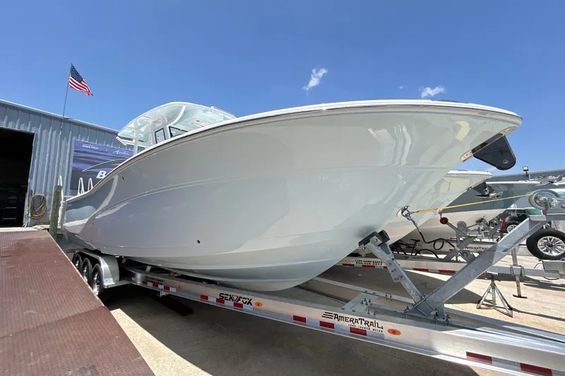 The Image of 2027 Sea Fox 328 Commander boat on trailer, displayed outdoors under clear blue sky. - 1