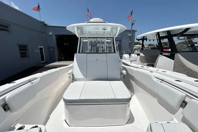 Slide: The Image of 2027 Sea Fox 328 Commander boat interior with seating, docked near a building. - 28
