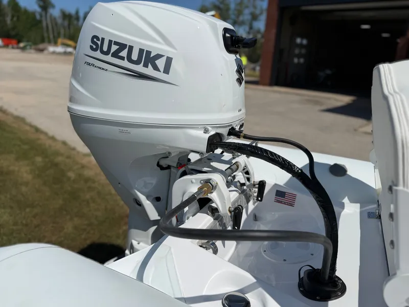 Slide: The Image of A Novurania 335DL with a Suzuki outboard motor, parked on an open lot. - 21