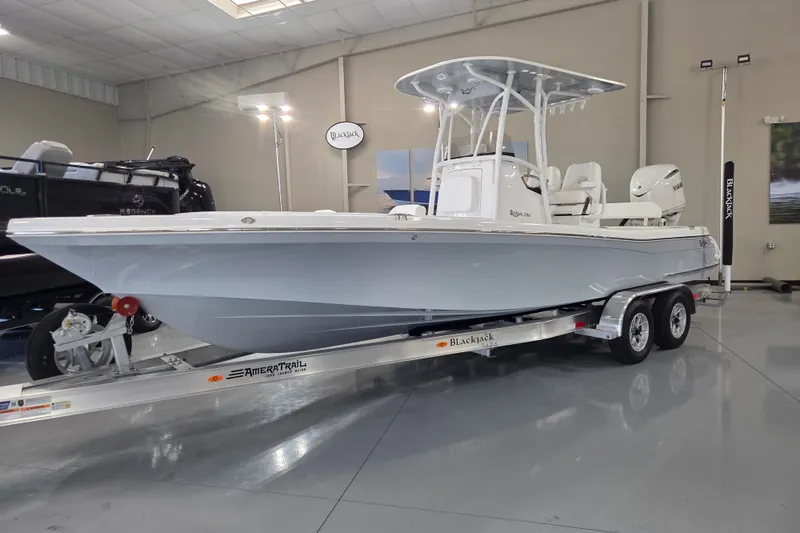 Slide: The Image of 2027 BlackJack 256 Coastal boat on trailer in showroom, featuring sleek design and modern amenities. - 1