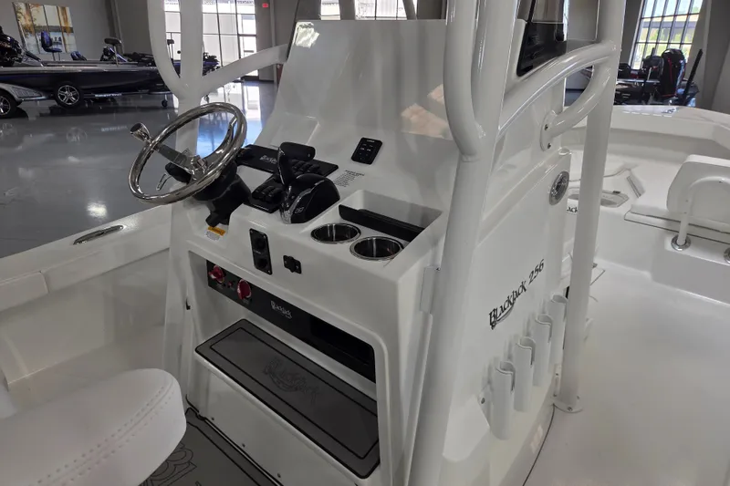 Slide: The Image of 2027 BlackJack 256 Coastal boat console with steering wheel and controls in showroom. - 7