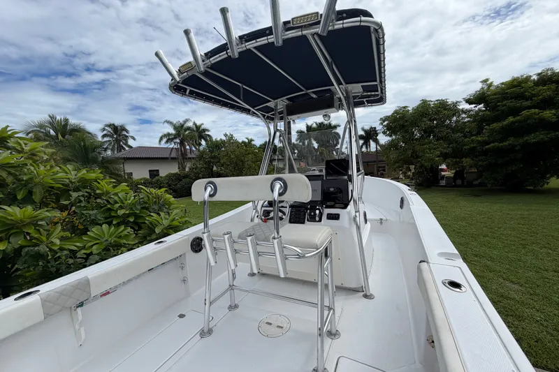 Slide: The Image of 2000 Cobia 274 Center Console boat with T-top, surrounded by lush greenery. - 11