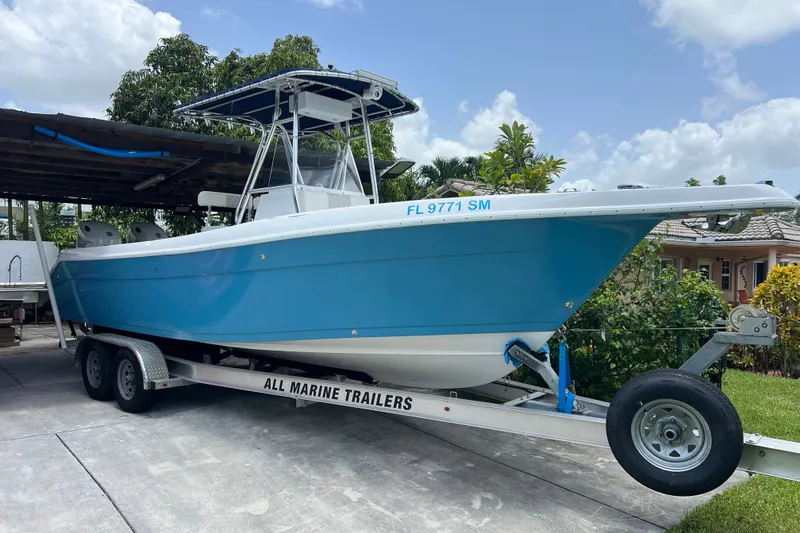 The Image of 2001 Cobia 274 Center Console boat on trailer, parked in driveway. - 0