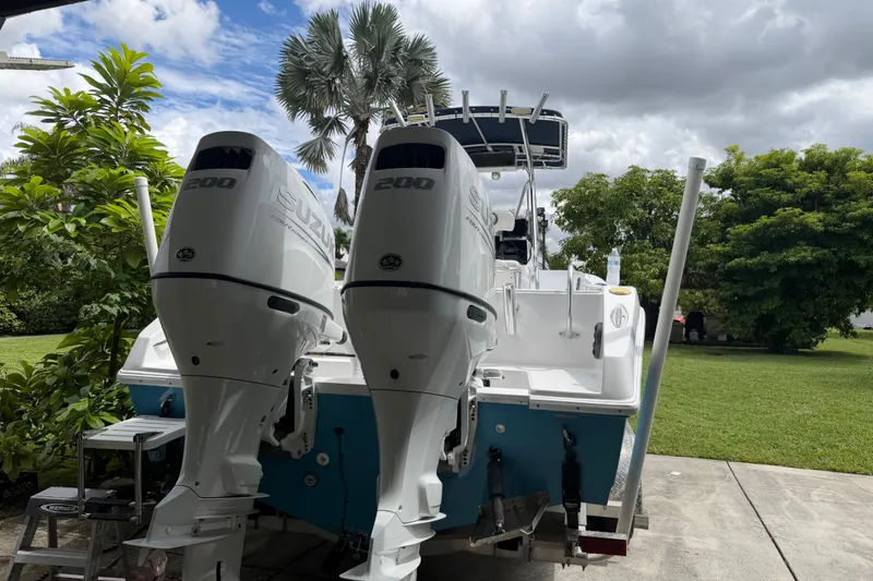 Slide: The Image of Cobia 274 Center Console boat with twin Suzuki 200 engines, parked outdoors. - 28