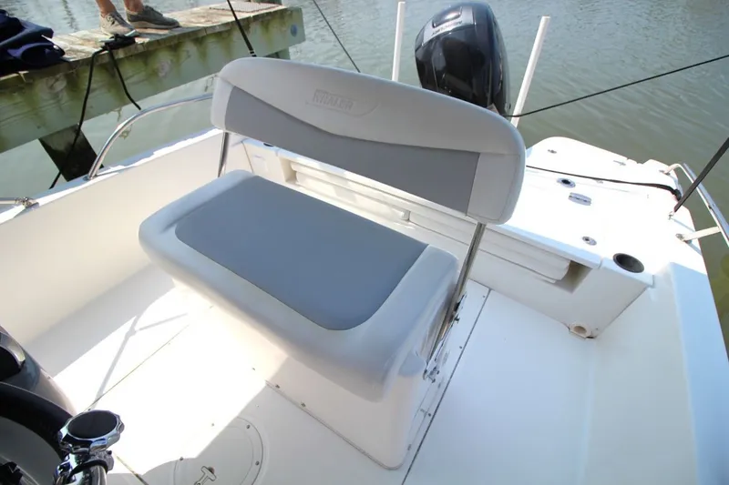 Slide: The Image of 2016 Boston Whaler 210 Dauntless boat interior with cushioned seating and outboard motor. - 11