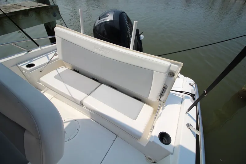 Slide: The Image of 2016 Boston Whaler 210 Dauntless boat with cushioned seating and outboard motor. - 15