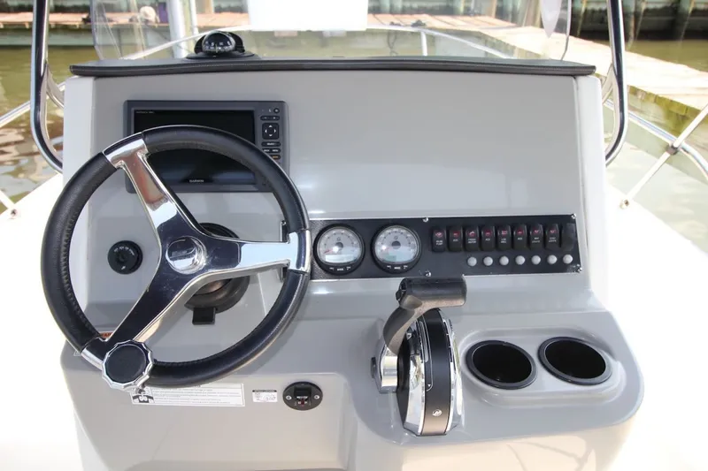 Slide: The Image of 2016 Boston Whaler 210 Dauntless helm with steering wheel, gauges, and controls. - 17