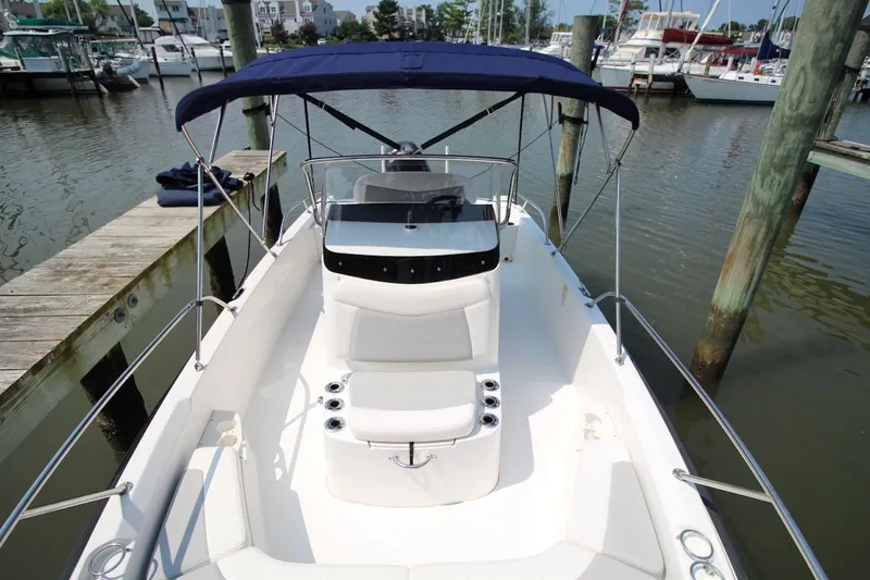 Slide: The Image of 2016 Boston Whaler 210 Dauntless boat docked at marina with blue canopy. - 12