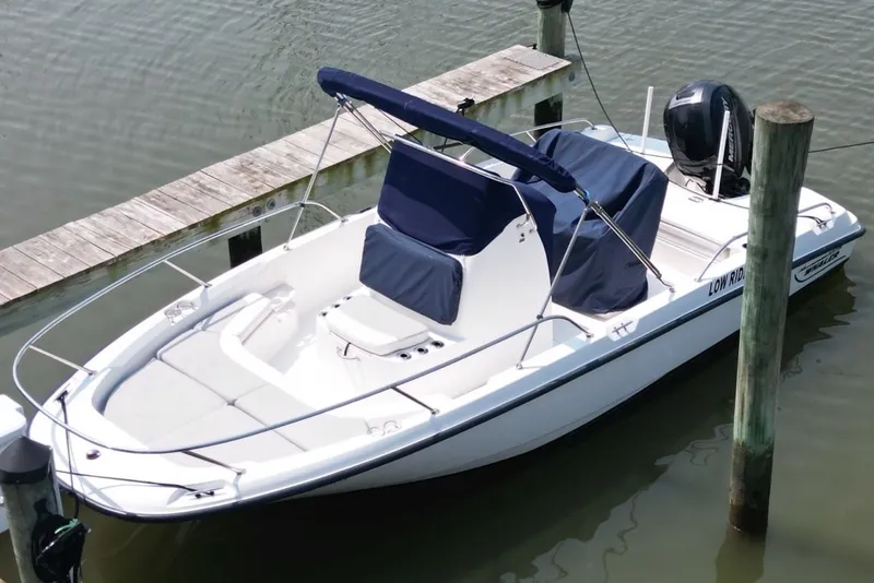 Slide: The Image of 2016 Boston Whaler 210 Dauntless boat docked on calm water. - 5