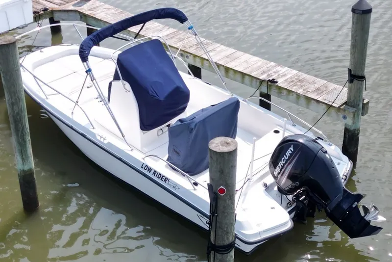 Slide: The Image of 2016 Boston Whaler 210 Dauntless boat docked with Mercury engine, covered seating. - 6