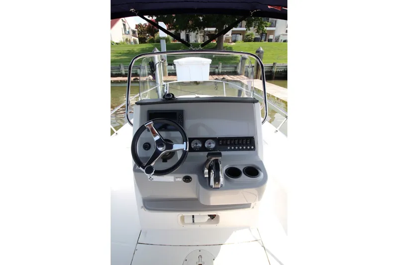 Slide: The Image of 2016 Boston Whaler 210 Dauntless boat console with steering wheel and controls. - 16