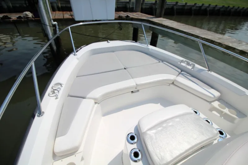 Slide: The Image of 2016 Boston Whaler 210 Dauntless boat interior with cushioned seating and cup holders. - 13