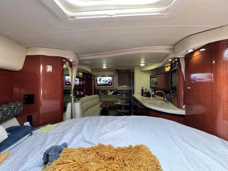 Slide: The Image of Interior of 2005 Sea Ray 340 Sundancer yacht with modern amenities and cozy bed. - 14