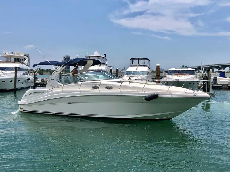 The Image of 2005 Sea Ray 340 Sundancer yacht docked in a marina on a sunny day. - 0