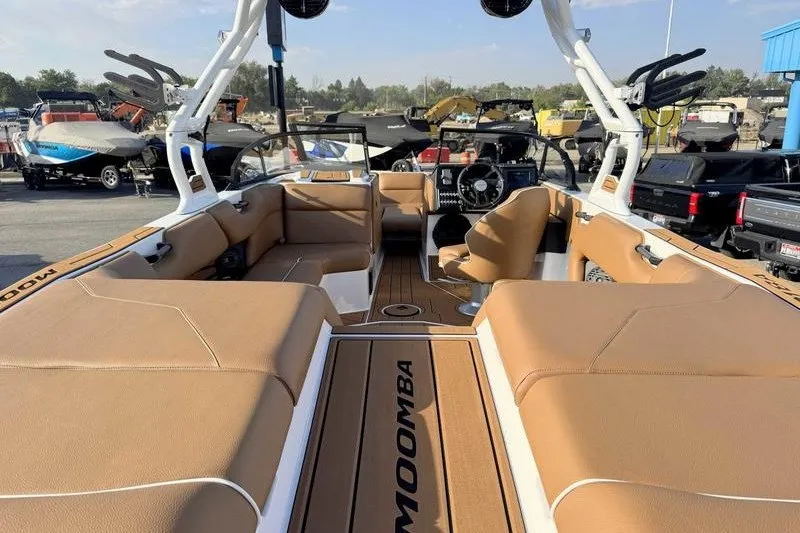 Slide: The Image of Interior view of 2027 Moomba Max boat with tan seating and modern dashboard. - 16