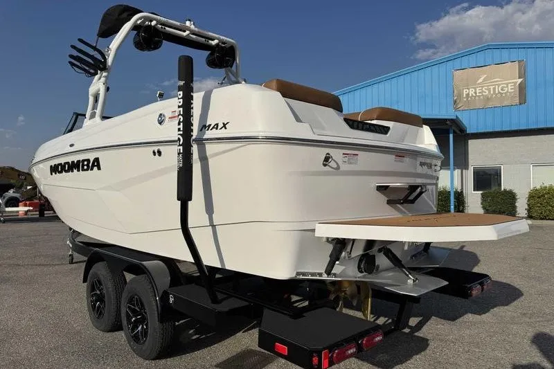 Slide: The Image of 2027 Moomba Max boat on trailer outside Prestige showroom, sunny day. - 8