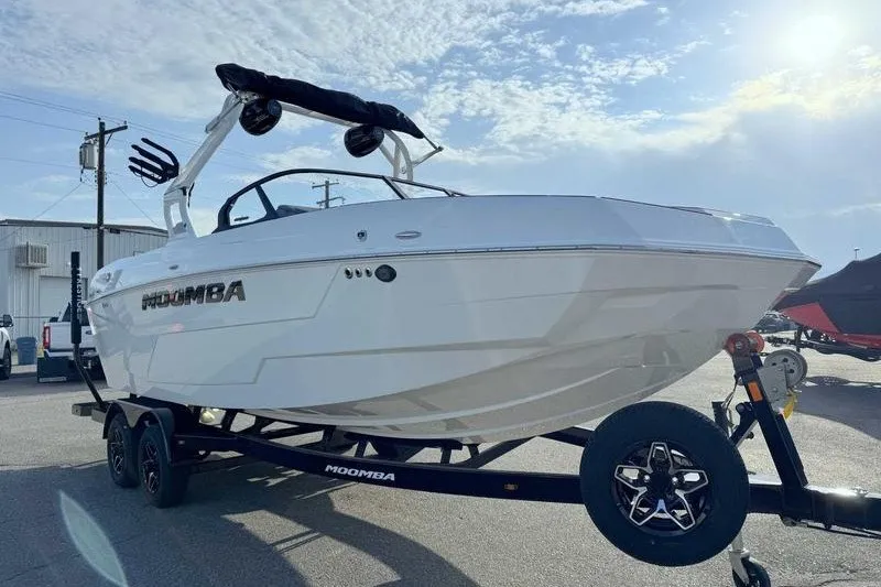 Slide: The Image of 2027 Moomba Max boat on trailer under clear sky. - 14