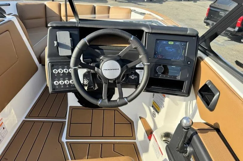 Slide: The Image of 2027 Moomba Max boat dashboard with steering wheel and digital display. - 2