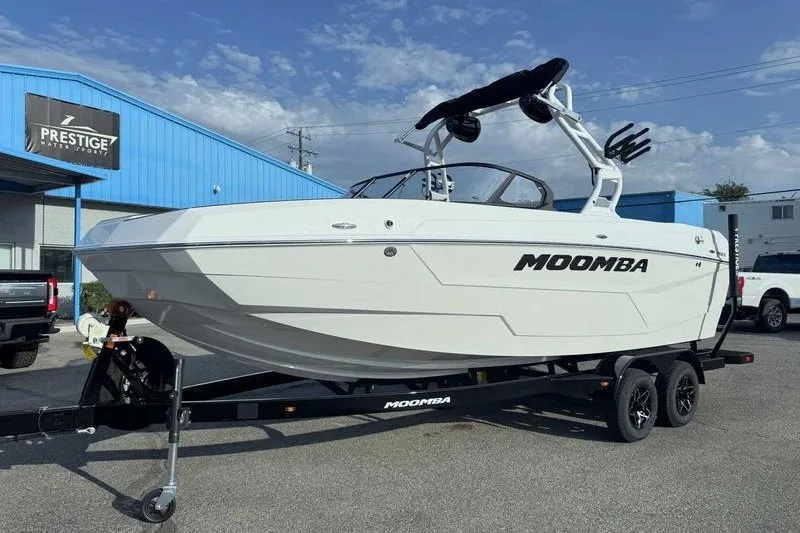 Slide: The Image of 2027 Moomba Max boat on trailer at dealership, clear sky background. - 7