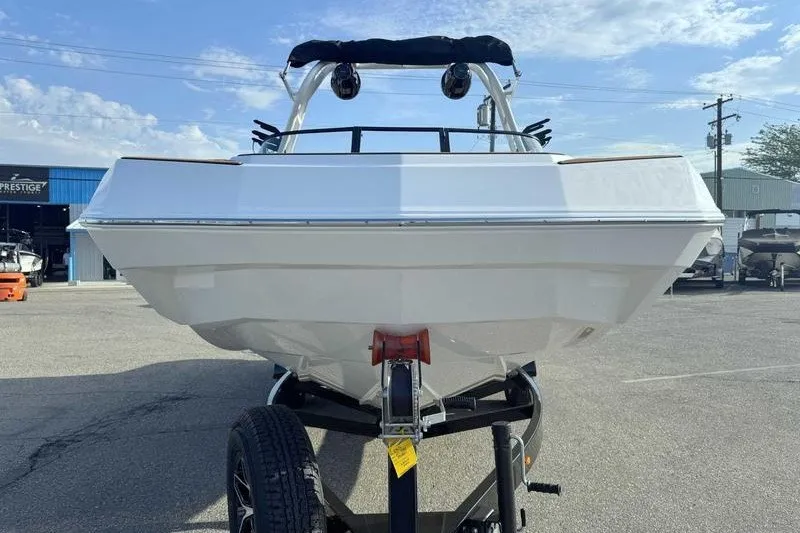 Slide: The Image of 2027 Moomba Max boat on trailer, front view under clear sky. - 12
