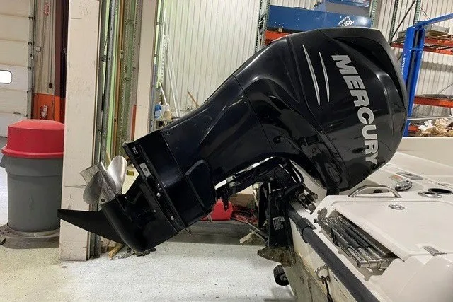 Slide: The Image of 2014 Boston Whaler 180 Dauntless with Mercury outboard motor in a garage setting. - 4