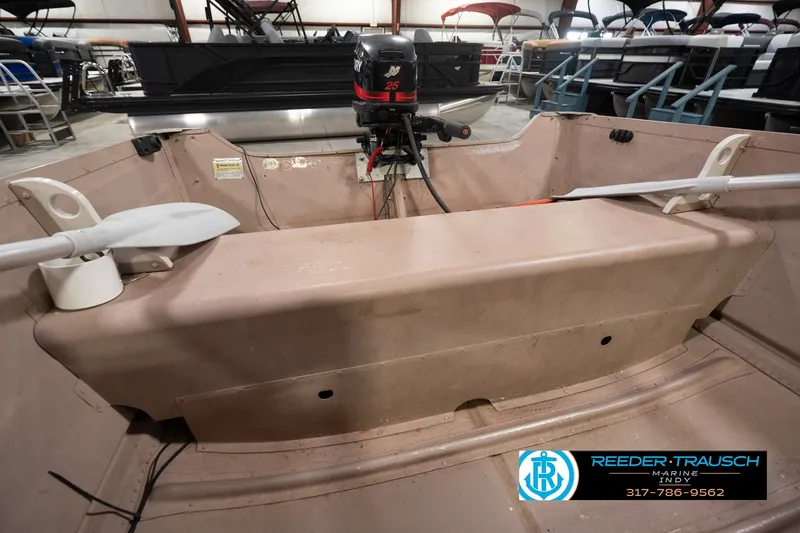 Slide: The Image of 2004 Smoker Craft Voyager boat interior with motor and oars in showroom. - 26