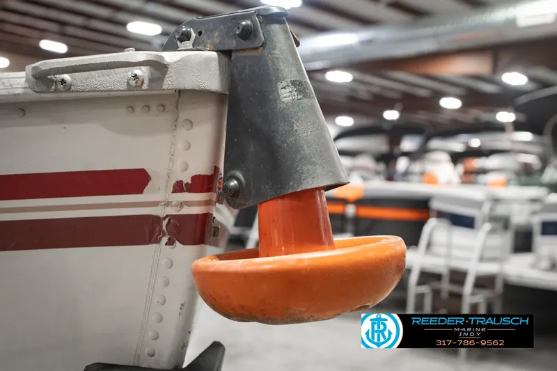 Slide: The Image of 2004 Smoker Craft Voyager boat detail with orange bumper in indoor showroom. - 35