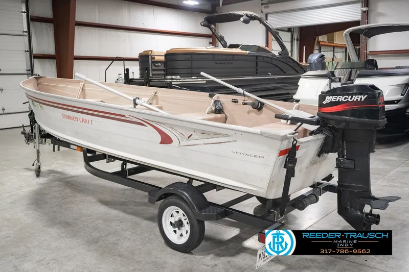 Slide: The Image of 2004 Smoker Craft Voyager boat with Mercury outboard motor on trailer in indoor showroom. - 9
