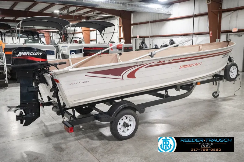 Slide: The Image of 2004 Smoker Craft Voyager boat with Mercury outboard motor on trailer in showroom. - 6