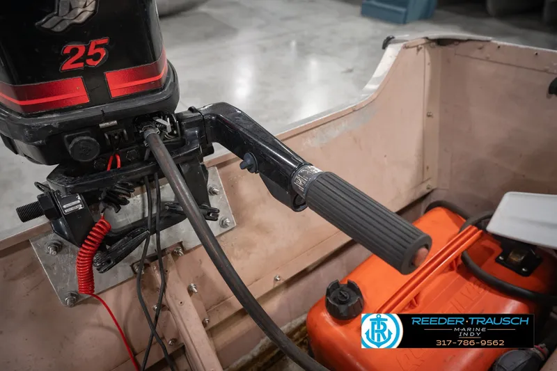 Slide: The Image of 2004 Smoker Craft Voyager boat with a 25 HP outboard motor and fuel tank. - 25