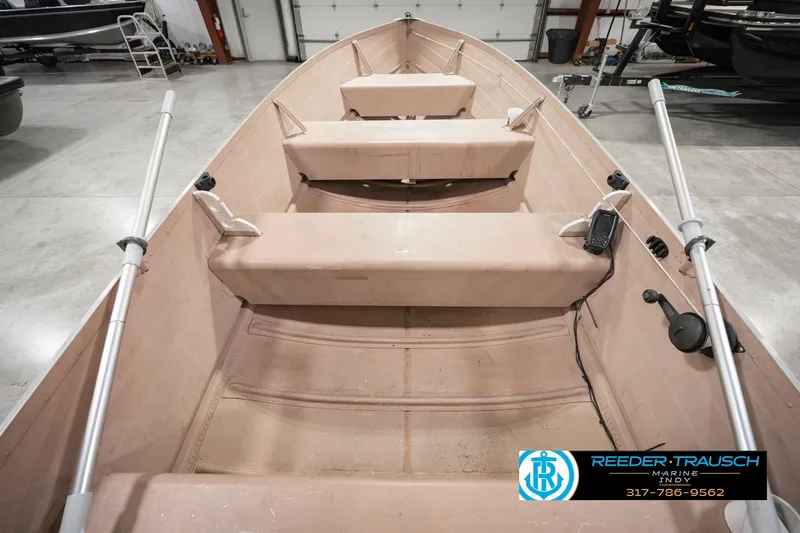 Slide: The Image of 2004 Smoker Craft Voyager boat interior with seating and oars in a showroom. - 17