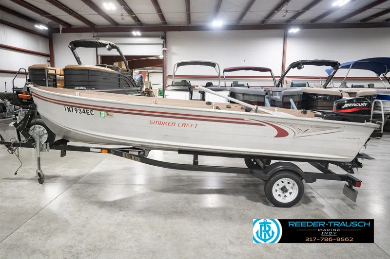 Slide: The Image of 2004 Smoker Craft Voyager boat on trailer in indoor showroom. - 10