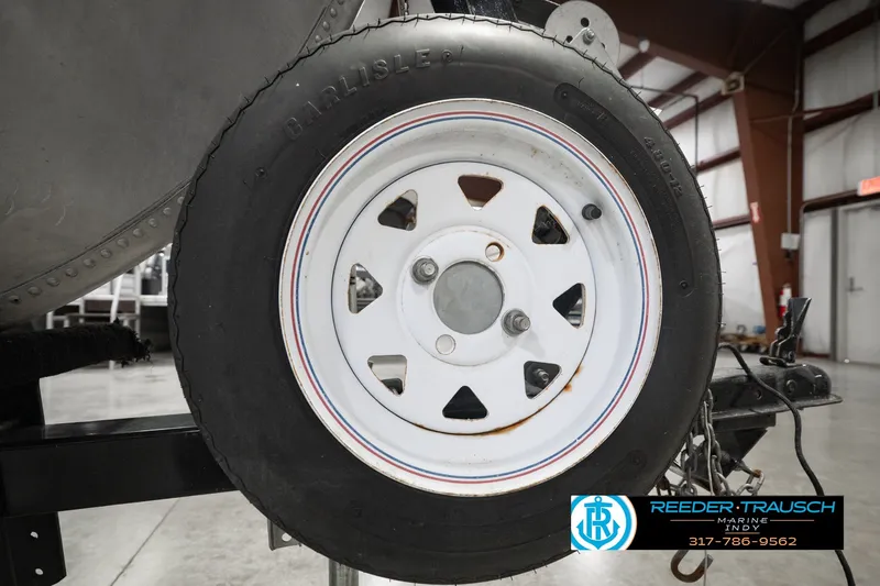 Slide: The Image of Trailer wheel of a 2004 Smoker Craft Voyager boat, featuring a white rim. - 45