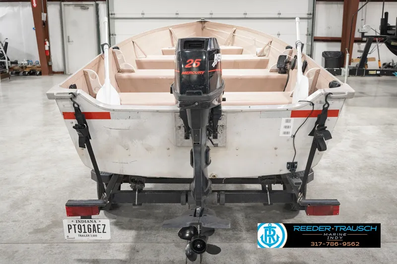 Slide: The Image of 2004 Smoker Craft Voyager boat with Mercury 25 outboard motor in a garage setting. - 8
