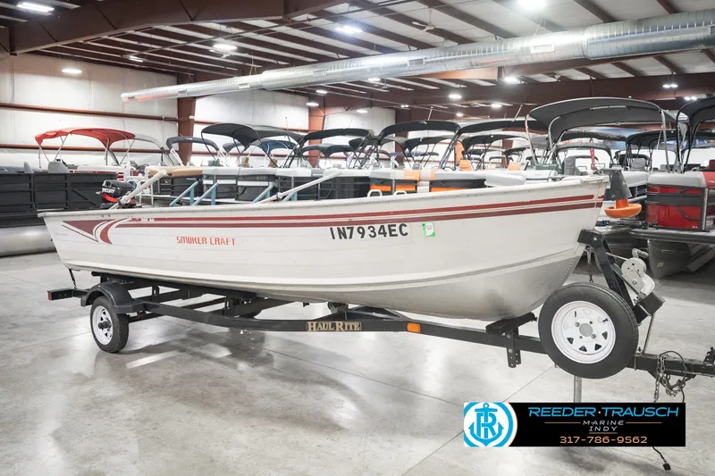 Slide: The Image of 2004 Smoker Craft Voyager boat on trailer in indoor showroom. - 4