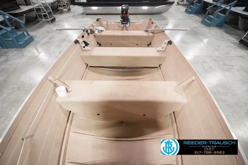 Slide: The Image of 2004 Smoker Craft Voyager boat interior with seating and motor, displayed in showroom. - 21