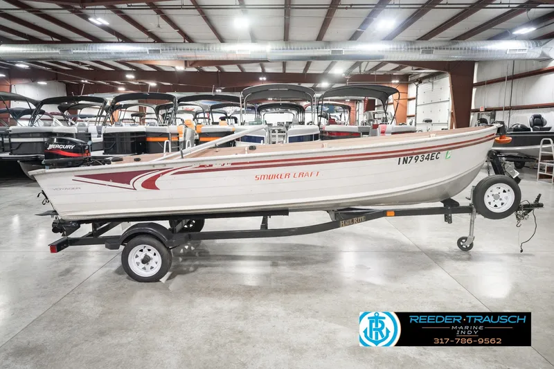 Slide: The Image of 2004 Smoker Craft Voyager boat on trailer in indoor showroom. - 5