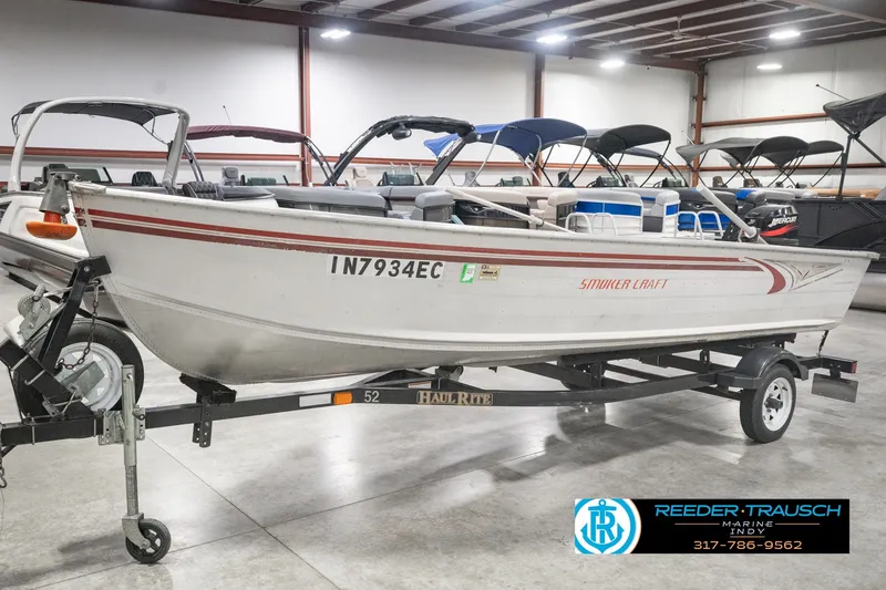 Slide: The Image of 2004 Smoker Craft Voyager boat on trailer in indoor showroom. - 1