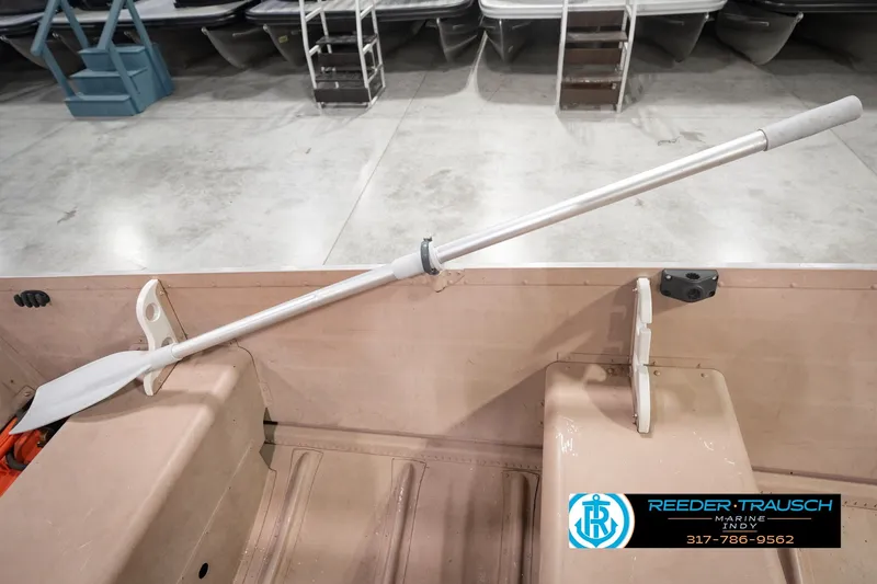 Slide: The Image of 2004 Smoker Craft Voyager boat interior with oar and seating, displayed in showroom. - 33