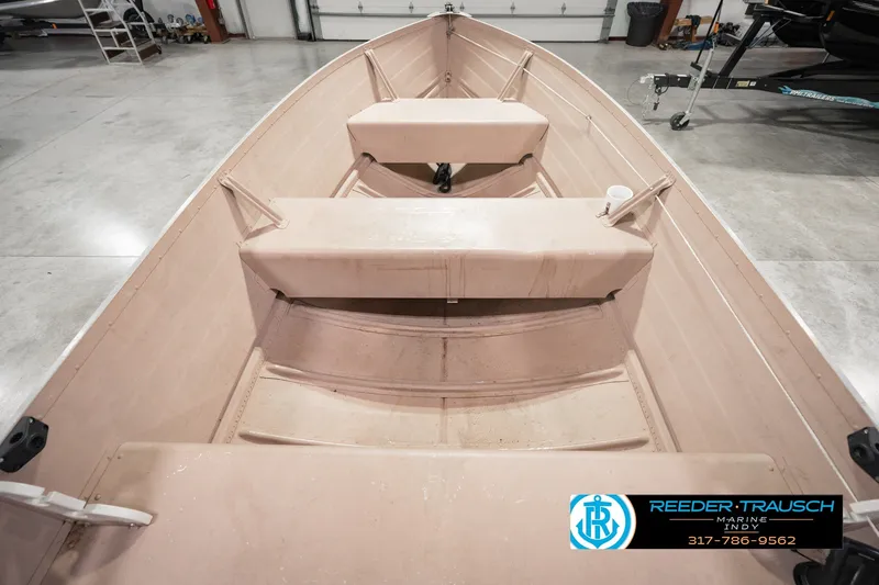 Slide: The Image of 2004 Smoker Craft Voyager boat interior with seating, displayed in a showroom. - 18