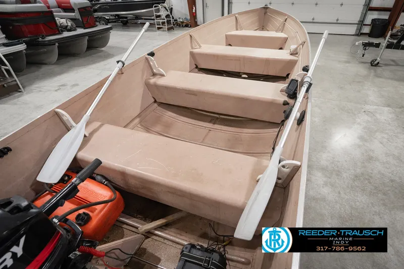 Slide: The Image of 2004 Smoker Craft Voyager boat with oars in a showroom, featuring beige seating and equipment. - 14