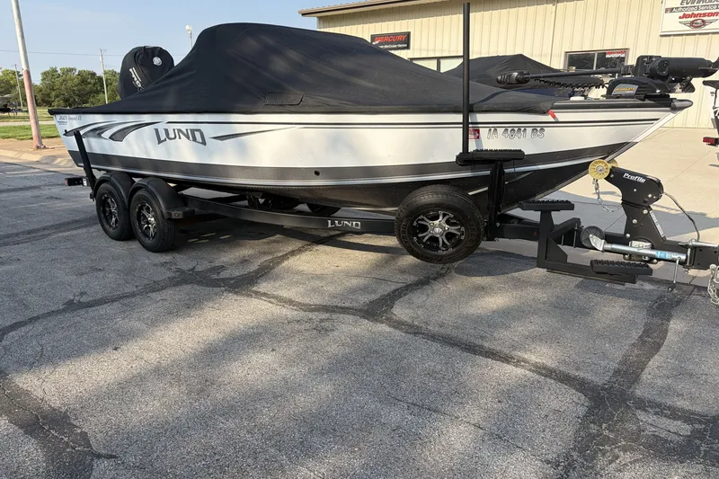 The Image of 2019 Lund 2025 Impact XS boat on trailer, covered and parked outdoors. - 0