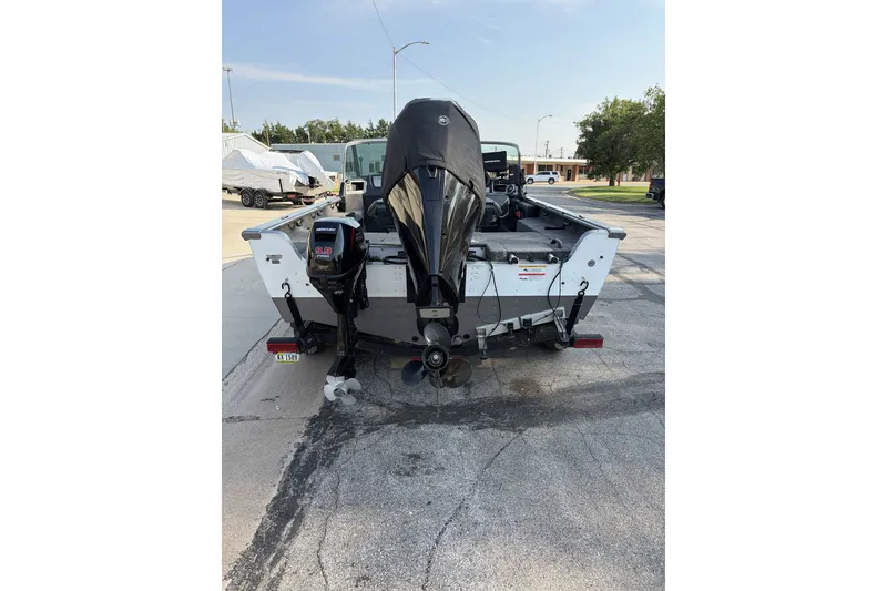 Slide: The Image of 2019 Lund 2025 Impact XS boat with dual outboard motors, parked on a trailer. - 3