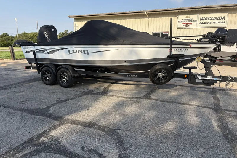 Slide: The Image of 2019 Lund 2025 Impact XS boat on trailer, covered, parked at dealership. - 1