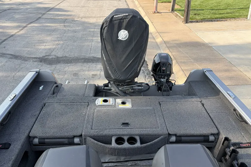 Slide: The Image of 2019 Lund 2025 Impact XS boat with covered outboard motor, parked on pavement. - 4