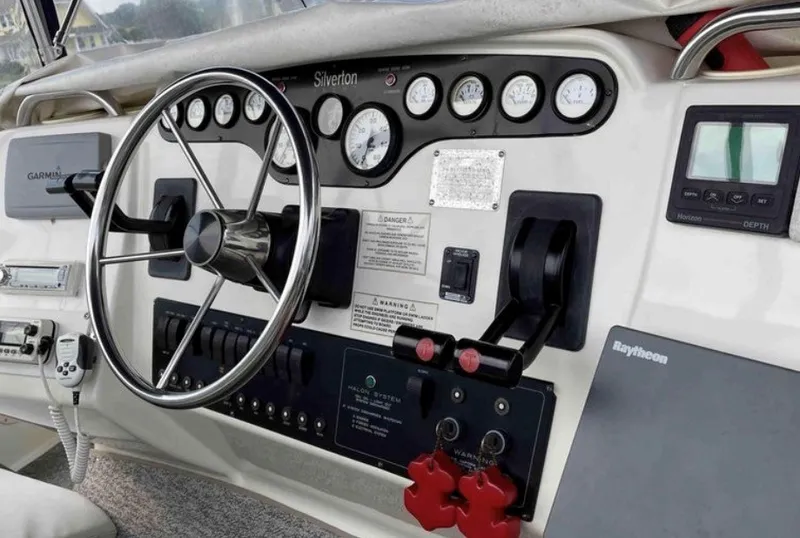 Slide: The Image of Dashboard of the 1997 Silverton 372 Motor Yacht with steering wheel, gauges, and navigation equipment. - 17