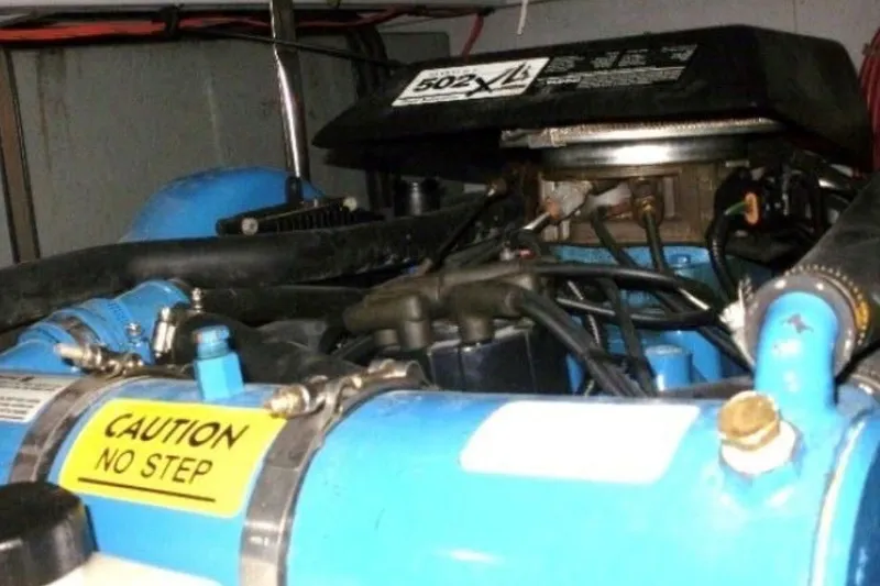 Slide: The Image of Engine room of a 1997 Silverton 372 Motor Yacht with a blue engine and "Caution No Step" sign. - 28
