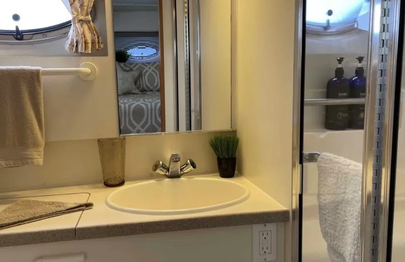 Slide: The Image of The image shows the bathroom of a 1997 Silverton 372 Motor Yacht with a sink and shower. - 15